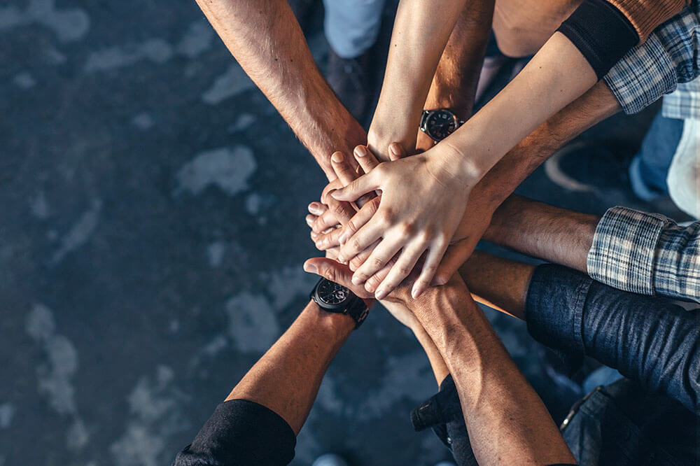 carrerrs2 team of people with hands in to show teamwork